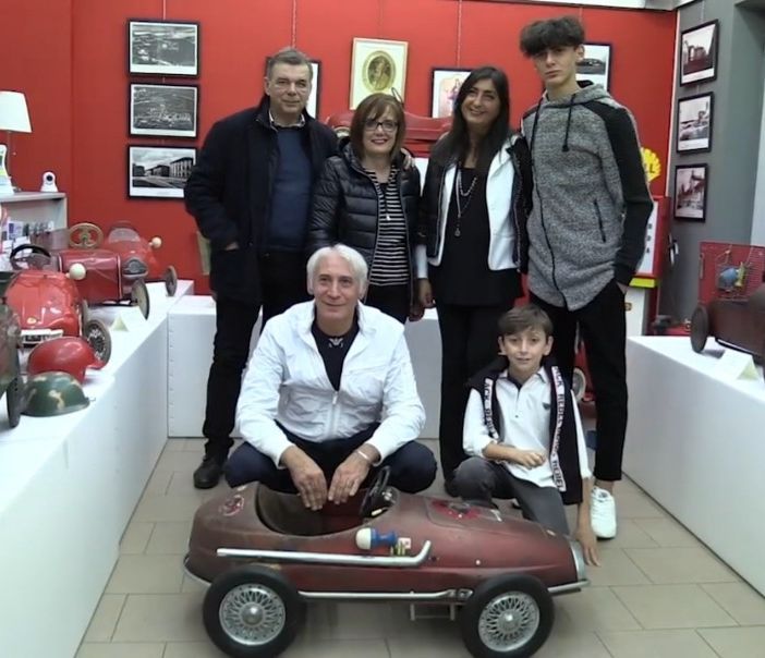 Persone accovacciate vicino a un modellino di auto in scala