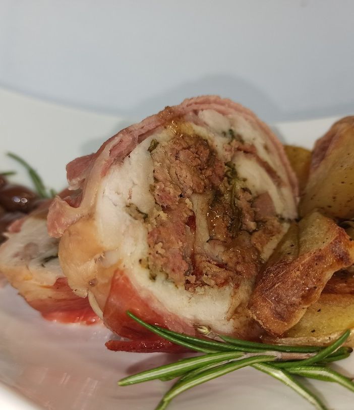 Rolata di coniglio bardata al bacon contornata di patate al forno