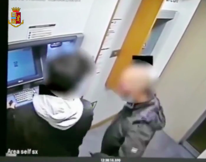 Il rapinatore con il ragazzo al bancomat