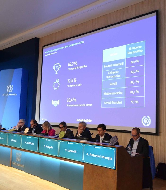 convegno in una sala con palco rialzato e schermi illuminati