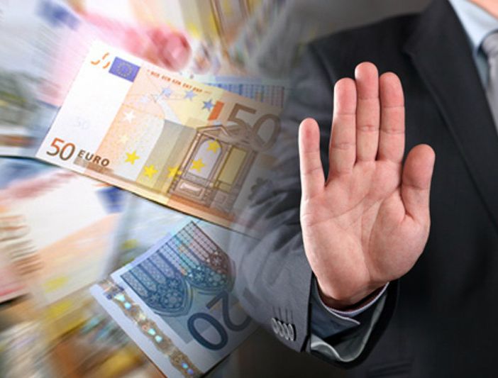 Mano che ferma di fronte a denaro contante