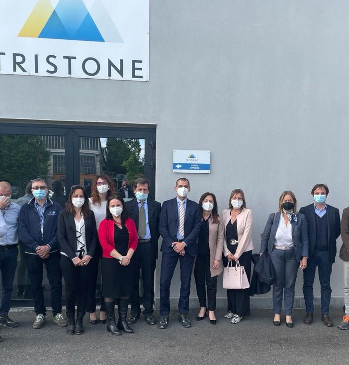 Delegazione in visita di fronte a un'azienda