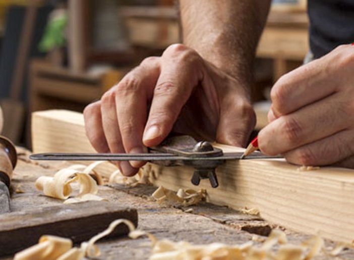 Artigiano al lavoro con mano che lavora il legno