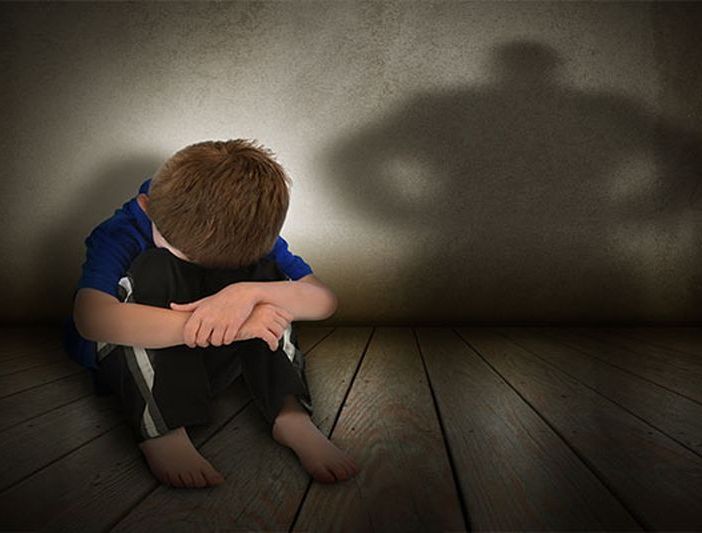 Bambino in difficoltà seduto a terra