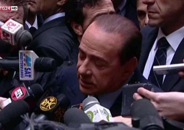 Silvio Berlusconi circondato dai microfoni