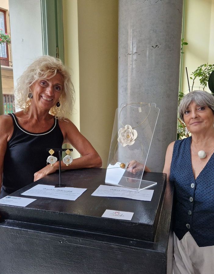 Due persone in posa vicino a opere di ceramica in mostra