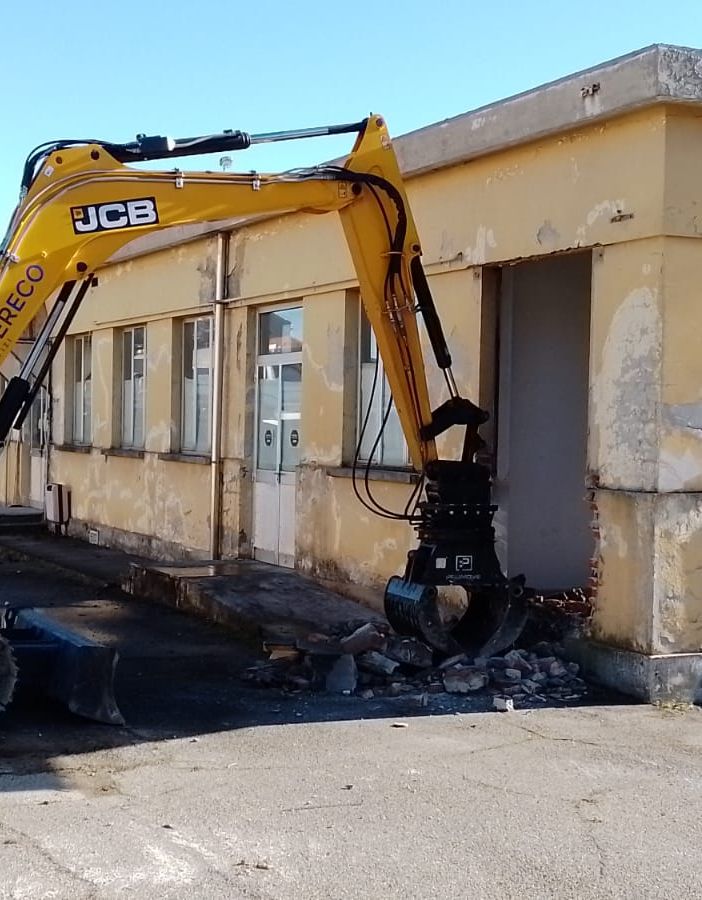 Lavori con pala meccanica che demolisce