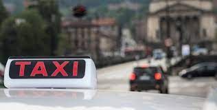 Taxi con insegna e sfondo torinese