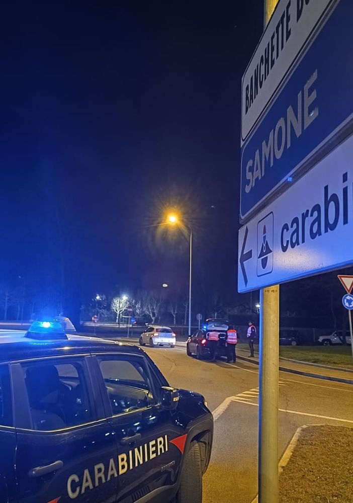 auto dei carabinieri di notte vicino a cartelli stradali
