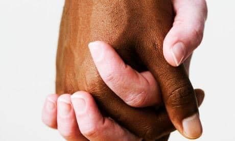 mani di due colori diversi che si stringono