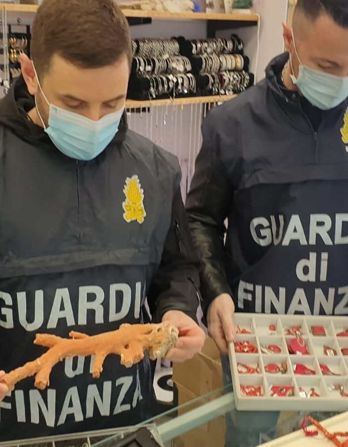 Uomini della Guardia di Finanza con prodotti sequestrati in mano