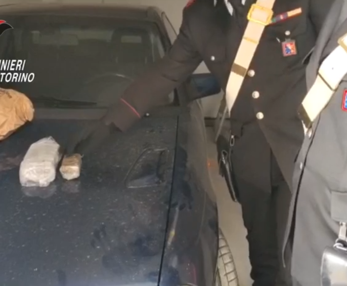 Due militari con la droga sequestrata appoggiata a un cofano