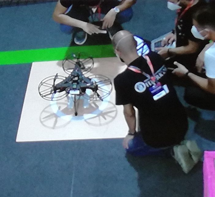 persone inginocchiate intorno a un drone
