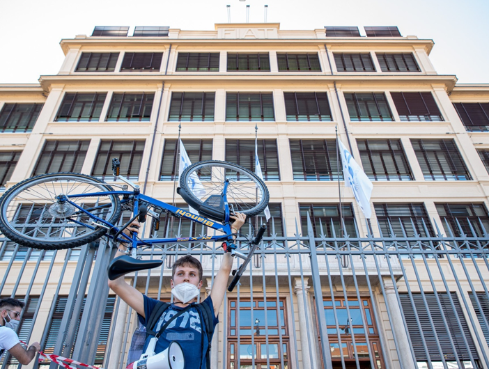 ragazzo che solleva una bicicletta davanti a ex sede Fiat
