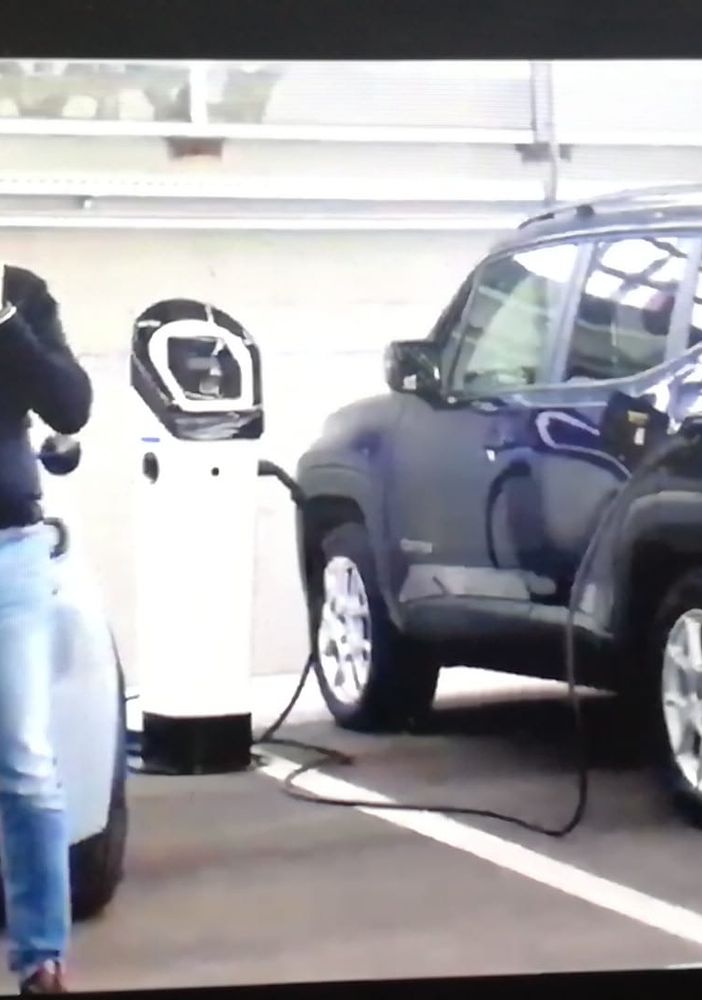 due uomini davanti a due auto elettriche