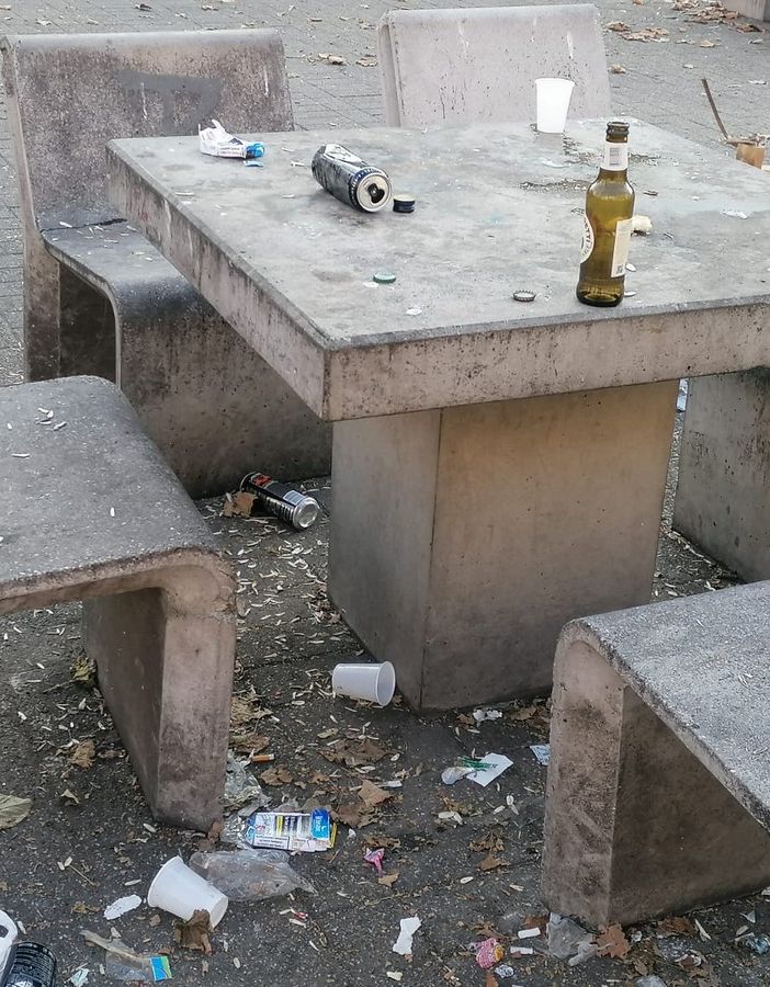 Tavoli pieni di bottiglie e lattine di birra vuote