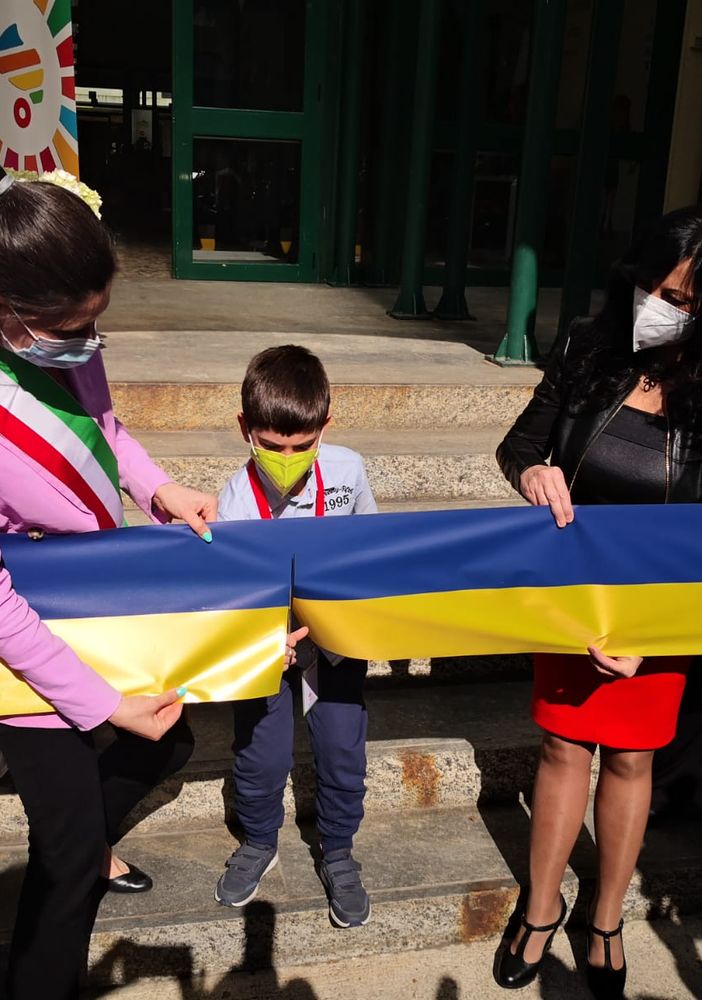 Chiara Appendino taglia nastro gialloblu con un bambino