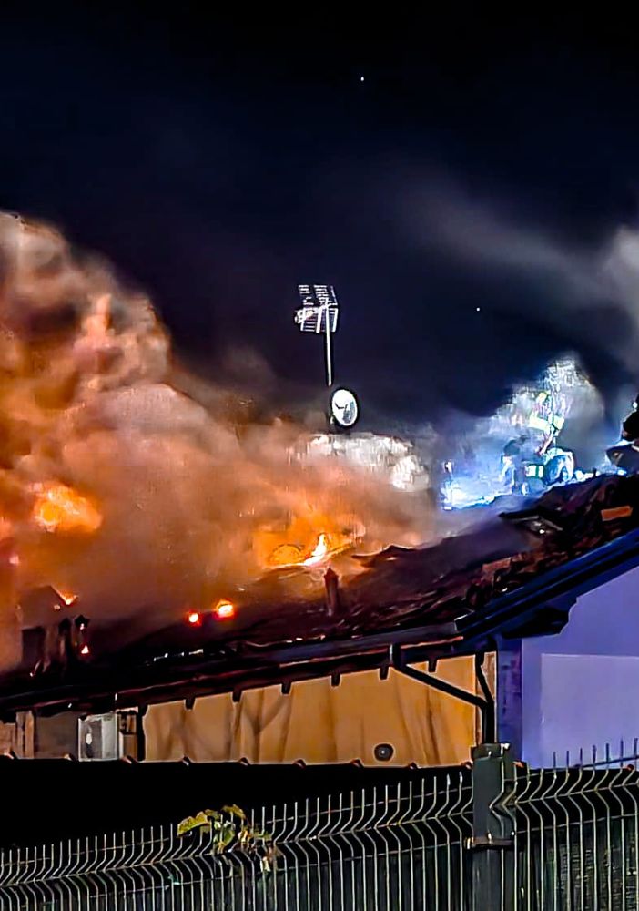 incendio di un tetto e vigili del fuoco in azione