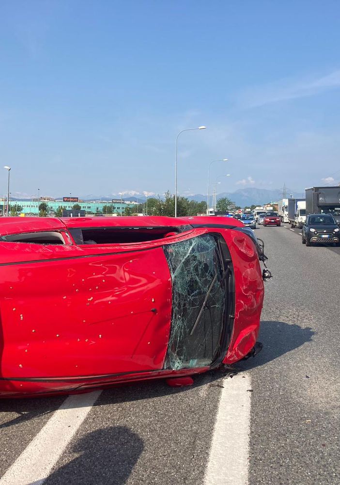 Una vettura ribaltata su un lato dopo uno scontro in tangenziale