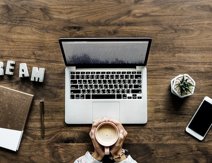 mani intorno a una tazza e un pc