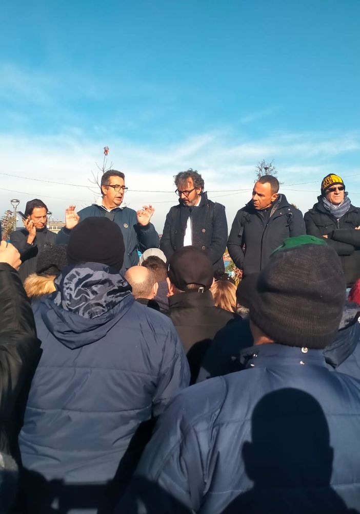 persone sotto il grattacielo della Regione