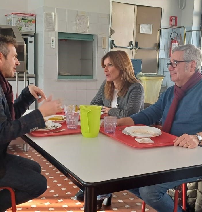 tre persone sedute a un tavolo