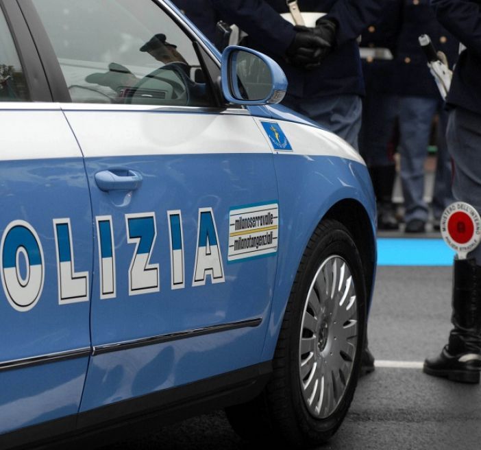 Auto della polizia con agenti in piedi all'esterno
