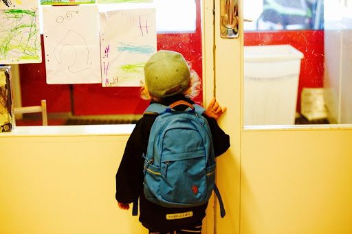 bimbo davanti alla porta della sua classe all'asilo