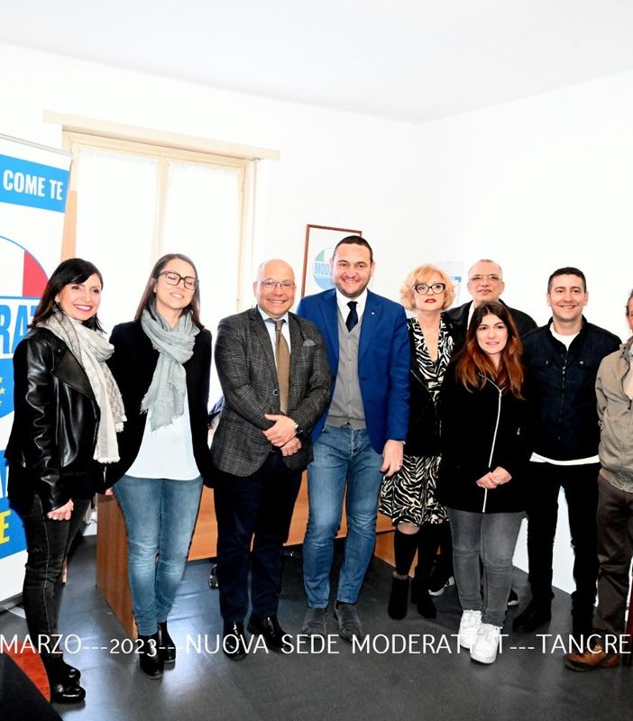 inaugurazione con tante persone in foto di gruppo davanti a una scrivania