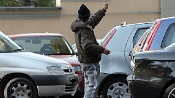parcheggiatore abusivo tra le auto