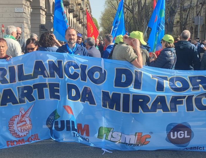 manifestazione in strada con striscione blu