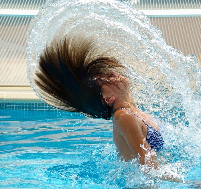 Una ragazza si fa il bagno in piscina