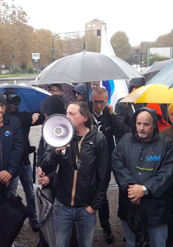 protesta sindacale con ombrelli e megafoni