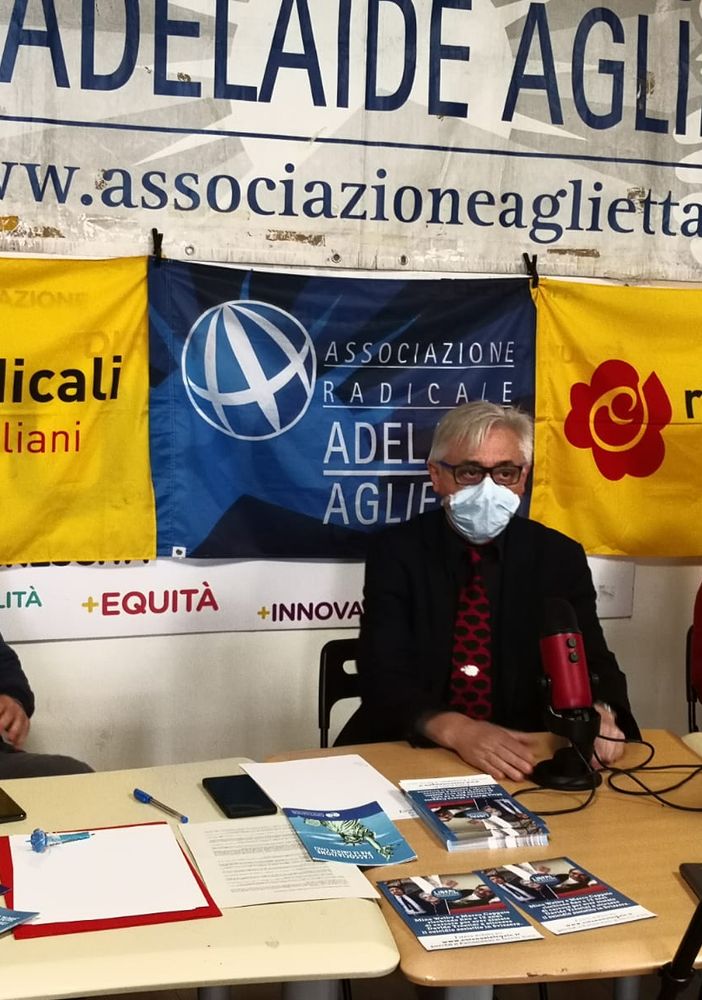 tavolo con persone sedute e bandiere di partito