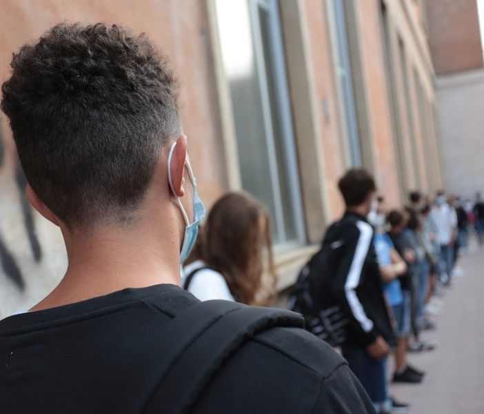 ragazzi in coda davanti a scuola