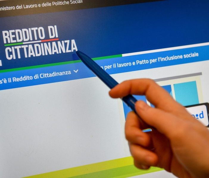 Richiesta del reddito di cittadinanza con una mano che indica la schermata del computer