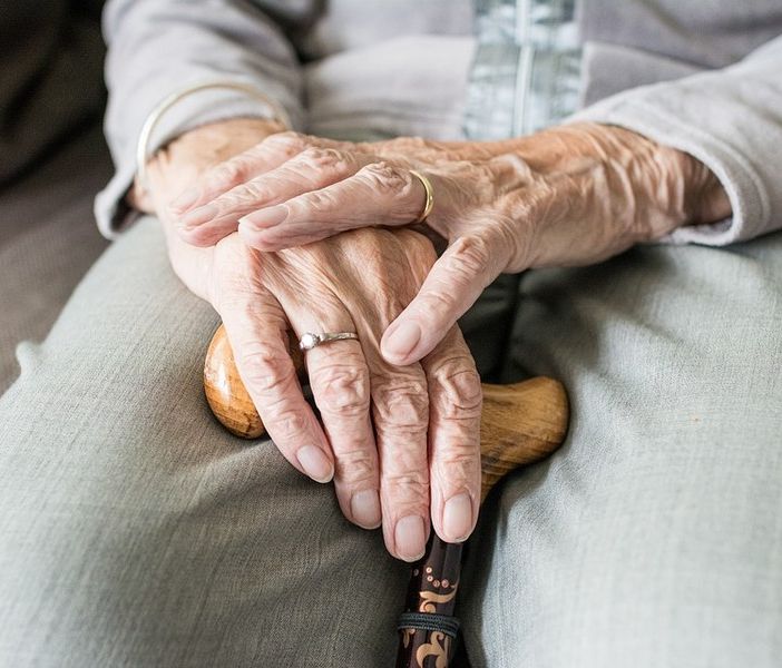 Anziano con le mani su un bastone