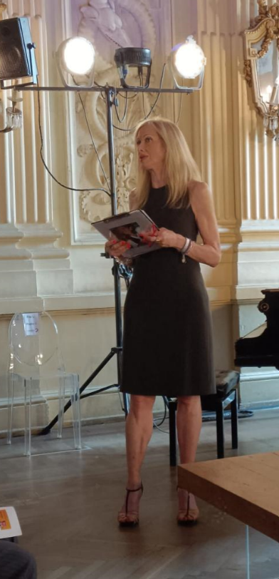 Donna che parla in piedi davanti a una platea