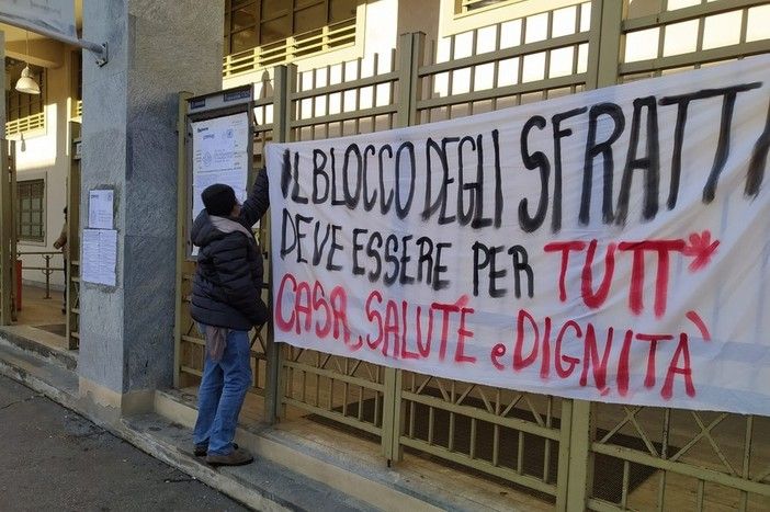 Persona che appende uno striscione sugli sfratti