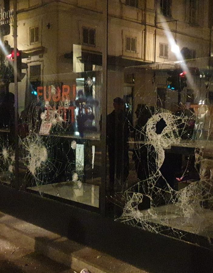 La vetrina di un negozio infranta durante durante il corteo pro Alfredo Cospito