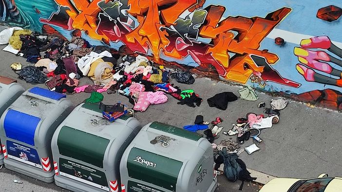 Marciapiede sommerso dai rifiuti e dai vestiti in Barriera Marciapiede sommerso dai rifiuti e dai vestiti in Barriera