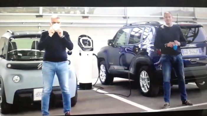 due uomini davanti a due auto elettriche due uomini davanti a due auto elettriche