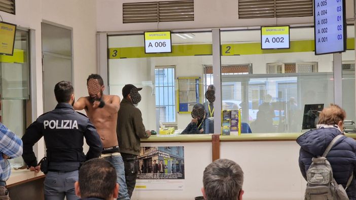 uomo nudo e poliziotto alle Poste