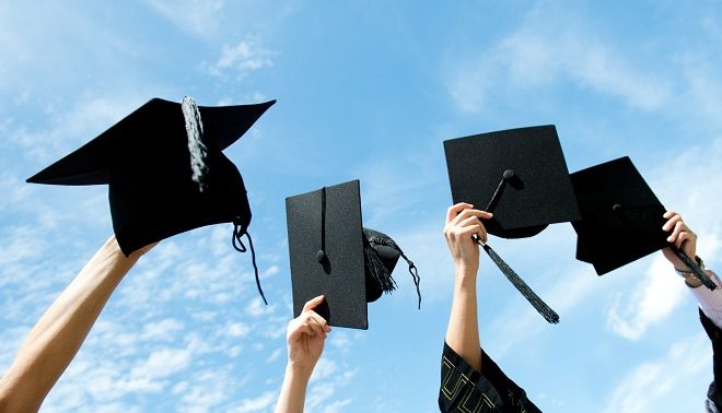 laureati che lanciano il cappello in aria