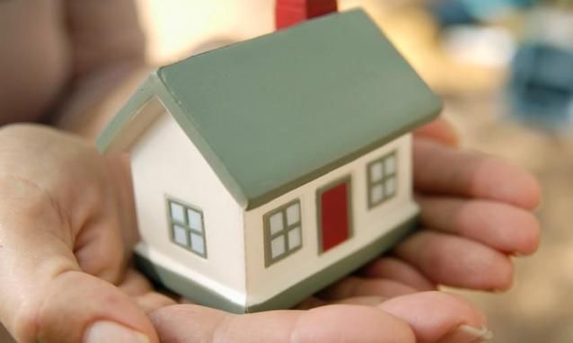 modellino di casa tenuto su un palmo di mano