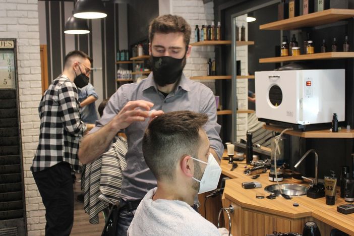 Barbiere al lavoro con un cliente Barbiere al lavoro con un cliente