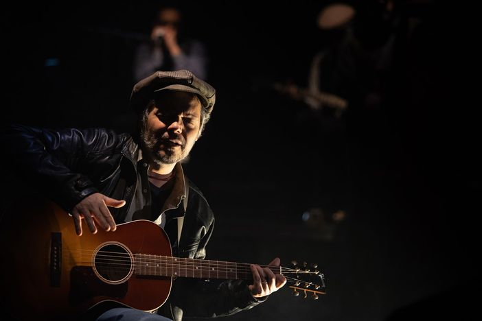 artista sul palco con una chitarra