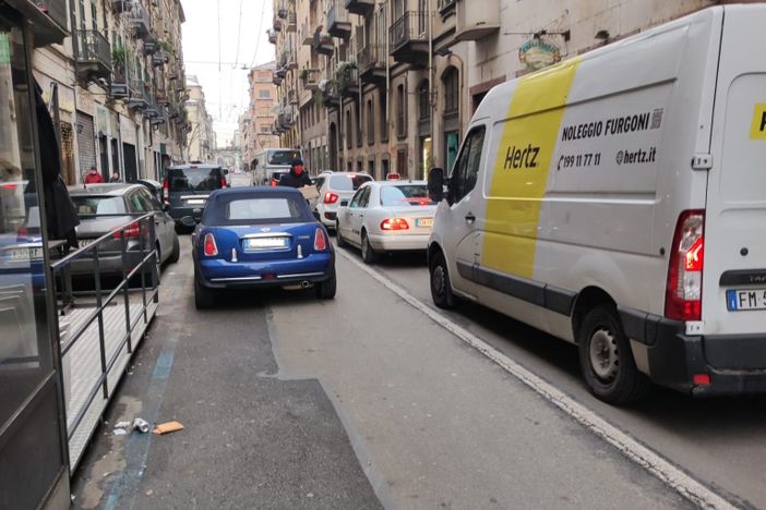 zona trafficata con auto e furgoni