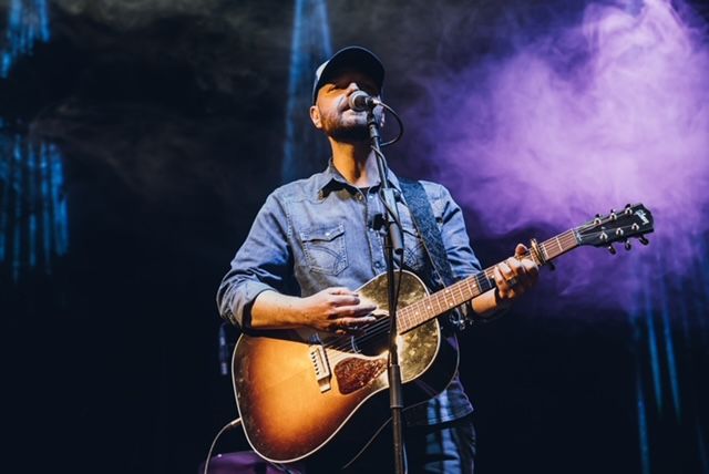 Musicista con chitarra sul palcoscenico Musicista con chitarra sul palcoscenico