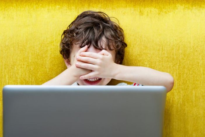 Bimbo spaventato davanti a uno schermo di computer
